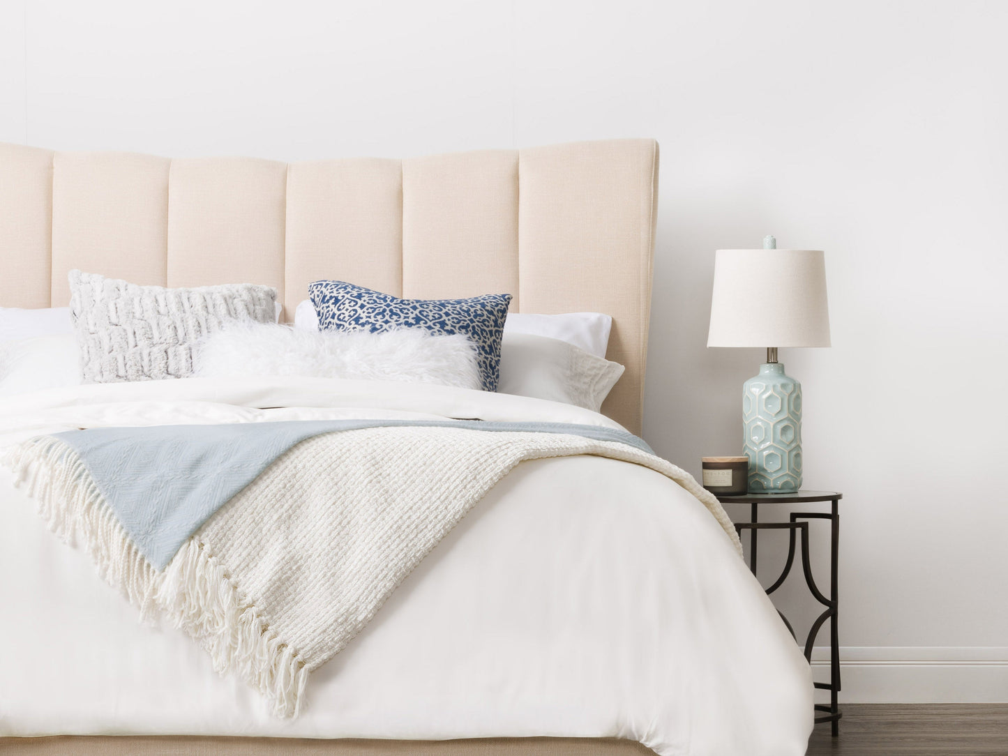 Cream channel tufted double/full bed with plush upholstery, sleek wooden legs, and elegant vertical stitching. Perfect for modern bedrooms seeking a blend of comfort and sophistication.