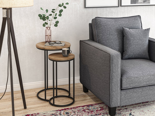 Light wood round nesting side tables with sleek black metal legs, minimalist design, smooth finish, and stackable functionality for space-saving versatility. Ideal for modern living rooms and small spaces.