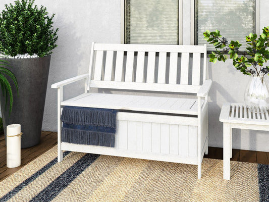 Washed white wooden patio storage bench with slatted backrest, sturdy armrests, and spacious under-seat storage. Ideal for outdoor seating and organization.