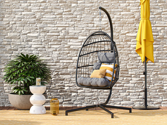 Grey hanging egg chair with plush cushions, woven rattan texture, and sturdy metal frame. Ideal for patios, this patio swing features a comfortable, cocoon-like design perfect for outdoor relaxation.
