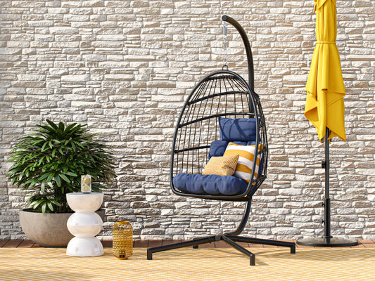 Blue hanging egg chair with cushioned seat, woven rattan design, and sturdy metal stand, perfect for patio relaxation.