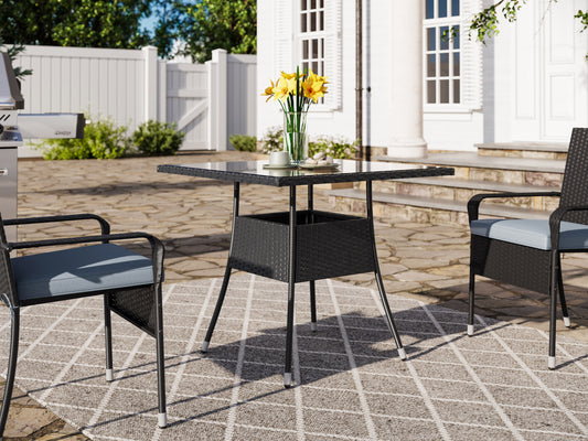 Square outdoor dining table with weather-resistant gray wicker frame, tempered glass top, and sturdy metal legs, perfect for patio or garden settings. Ideal for outdoor dining and entertaining.