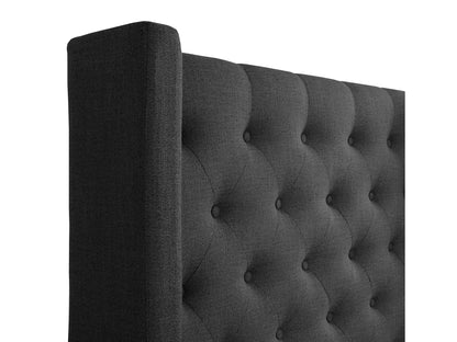 Dark grey tufted queen bed with plush upholstery, featuring a high, button-tufted headboard and sturdy wooden legs, perfect for modern bedroom decor.