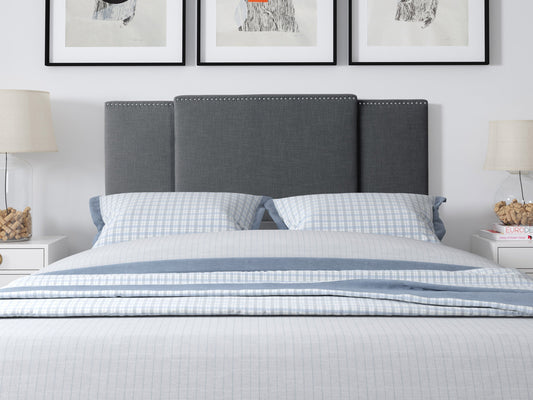 Dark grey adjustable headboard with tufted upholstery, sleek design, and soft fabric texture, suitable for queen and king size beds. Ideal for modern bedroom decor, offering customizable height settings.