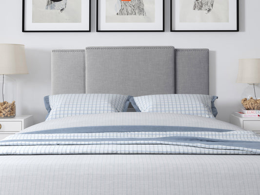 Adjustable grey headboard with tufted fabric, sleek design, and sturdy build, perfect for modern bedrooms.