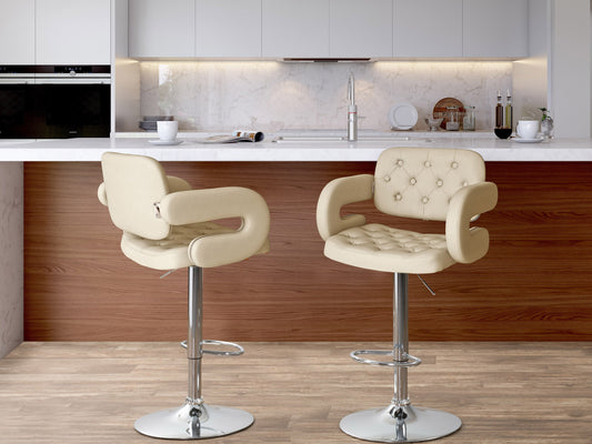 Set of 2 oatmeal-colored bar stools with arms, featuring plush fabric upholstery, wooden legs, and a footrest bar, perfect for kitchen counters or home bars.