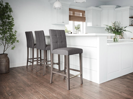 Silver grey bar height stool with cushioned fabric seat, sleek metal legs, and footrest. Ideal for modern kitchens or bars, this stool combines comfort and contemporary design.