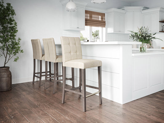 Beige fabric bar height stool with cushioned seat, dark wood legs, and footrest. Ideal for kitchen islands or home bars, this modern stool features a comfortable design and neutral color to match various decor styles.