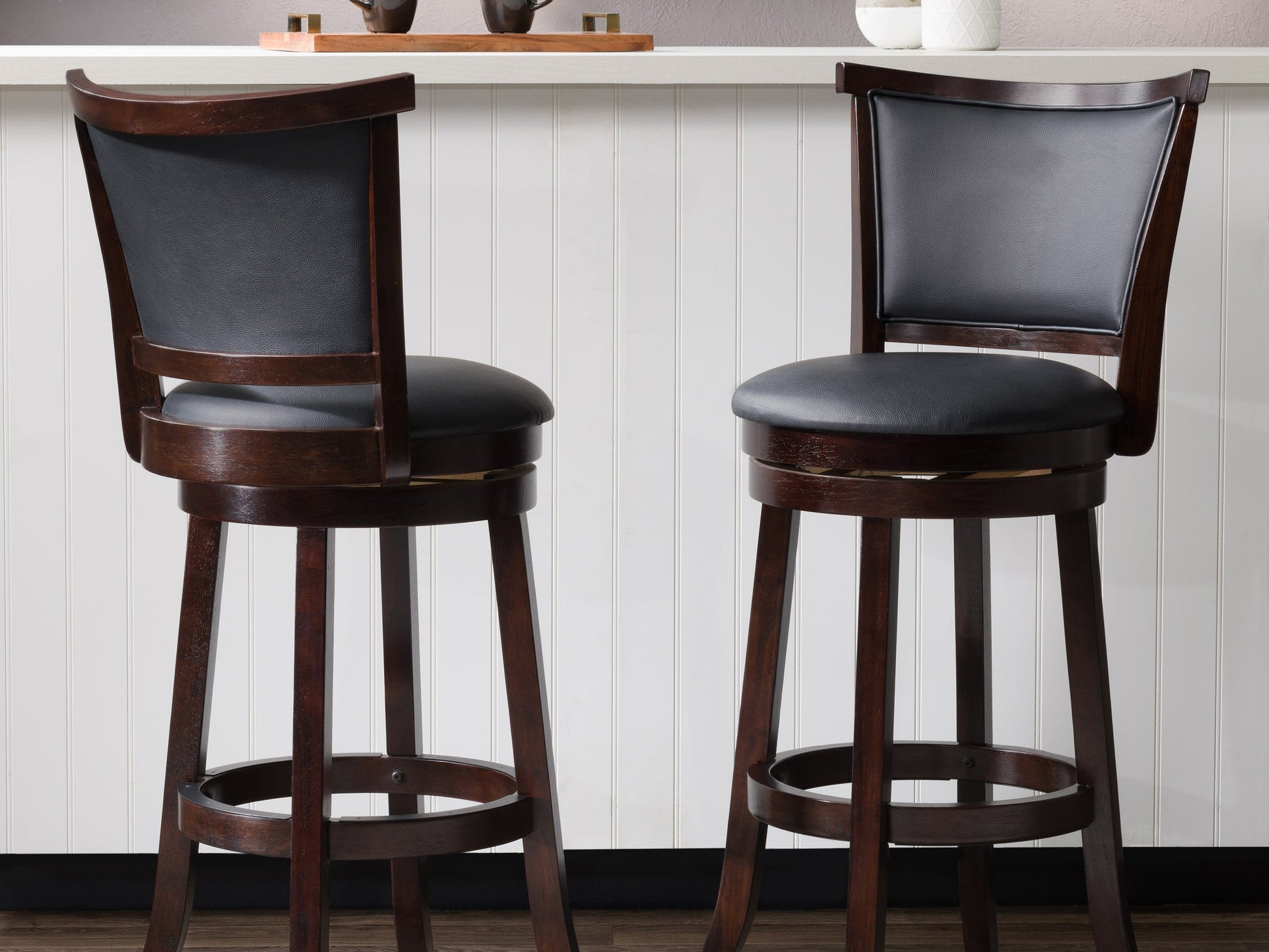 Set of 2 black bar height bar stools with sleek metal frames, cushioned seats, and footrests. Modern design with durable materials ideal for kitchen islands or home bars.