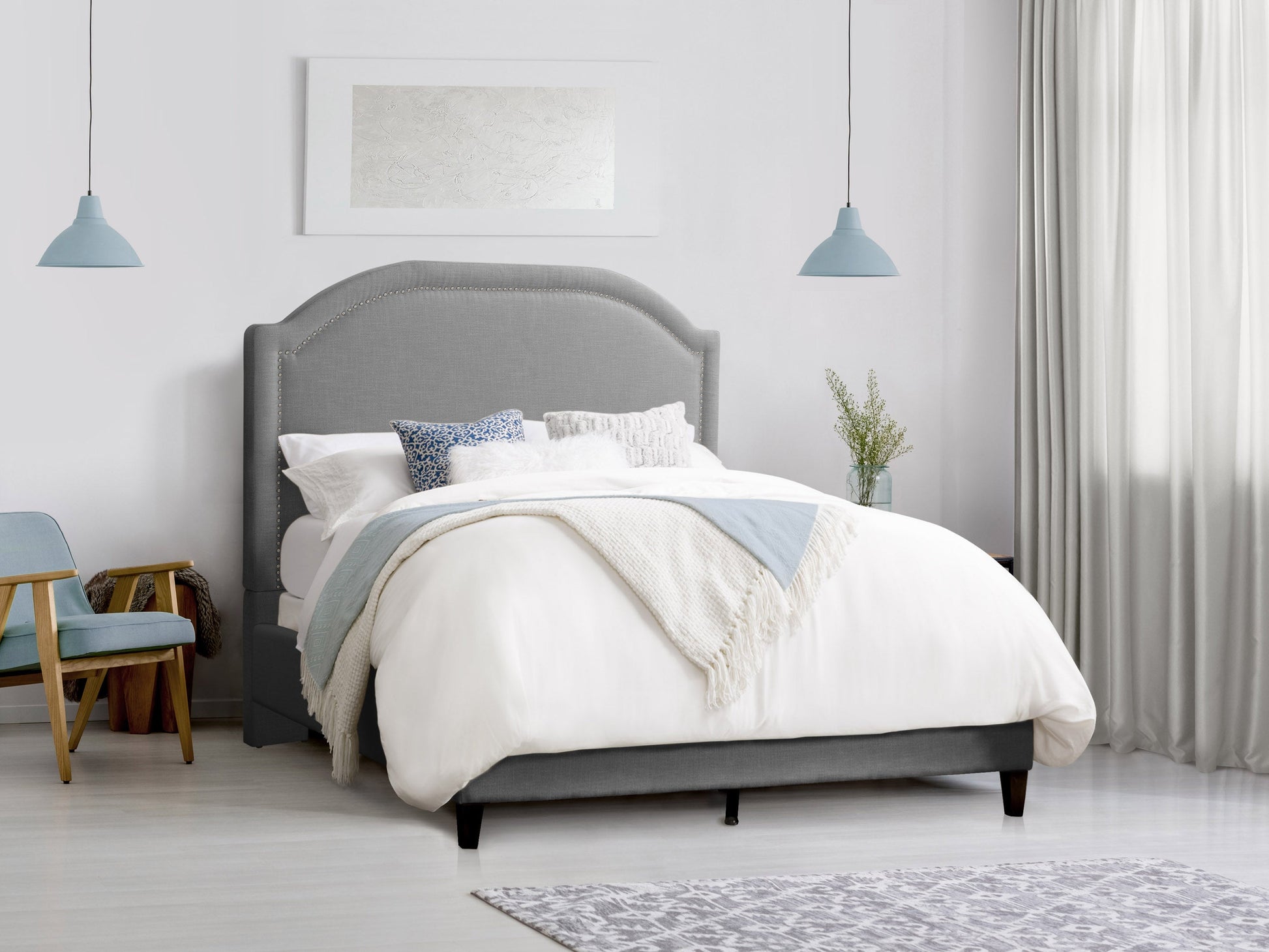 Grey upholstered queen bed with tufted headboard, soft fabric finish, and sturdy wooden legs. Ideal for modern bedrooms seeking comfort and style.