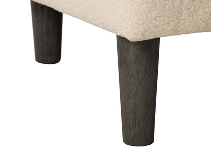 Cream boucle barrel accent chair with curved backrest, plush texture, and wooden legs. Chair features a modern design, perfect for living rooms or reading nooks.