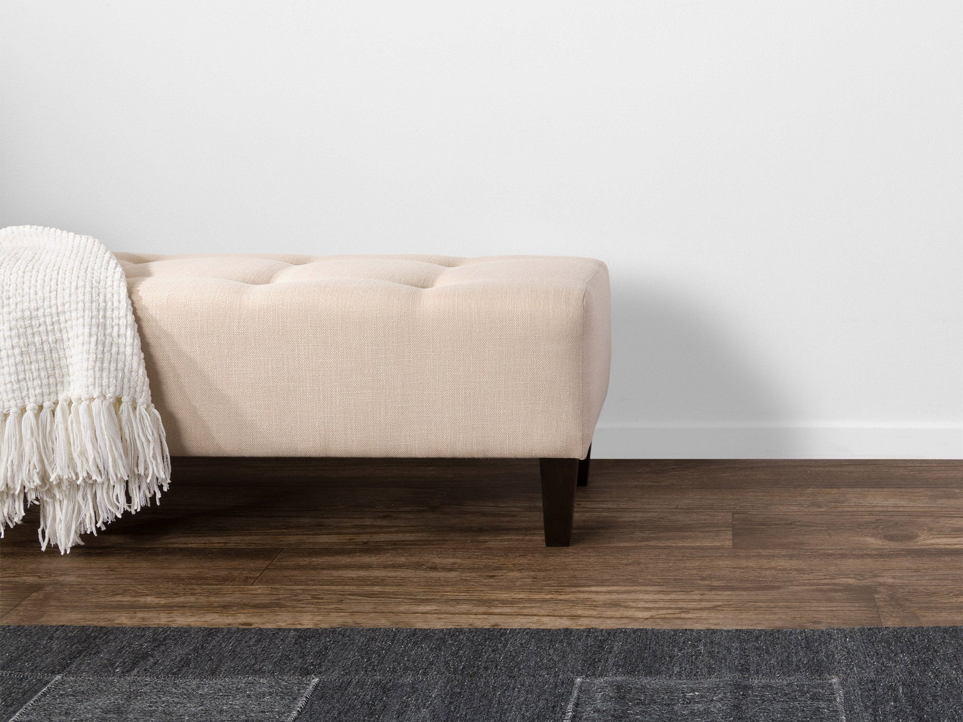 Cream accent bench with tufted upholstery, wooden legs, and a sleek design. The bench features a soft, cream-colored fabric with button detailing and dark wooden legs, perfect for entryways or living rooms.