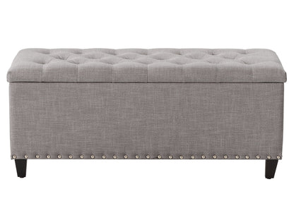 Light grey tufted storage ottoman with soft fabric upholstery, button-tufted top, and dark wooden legs. Features spacious interior storage and versatile design, perfect for living rooms or bedrooms.