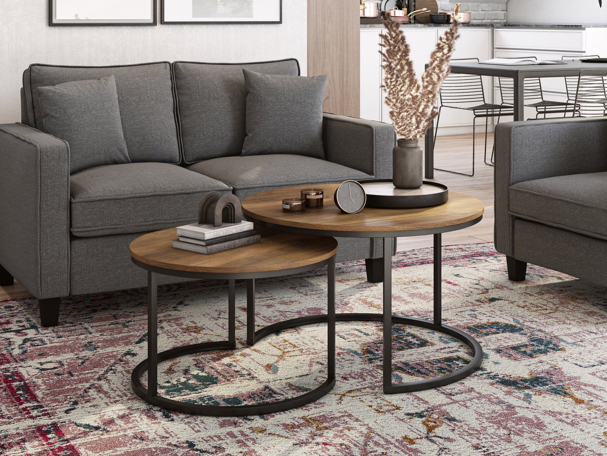 Round nesting coffee tables with brown wood tops, black metal legs, and a modern minimalist design. The larger table has a smooth surface, while the smaller table can be tucked underneath for space-saving versatility.