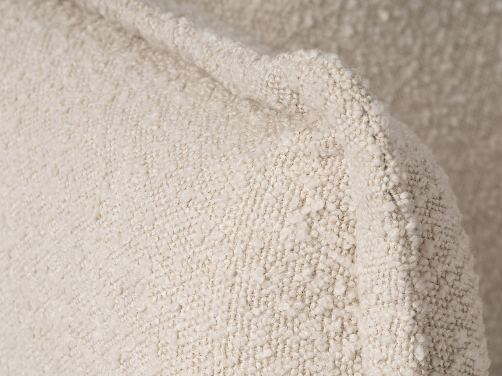 Modern boucle loveseat in cream, featuring soft textured fabric, sleek wooden legs, and plush cushioning for comfort and style, perfect for contemporary living rooms or cozy reading nooks.