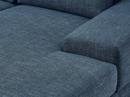 Modern blue sectional sofa, right-facing with plush cushions, sleek lines, and a durable fabric finish, perfect for contemporary living rooms. Features include adjustable headrests and stainless steel legs for added style and support.