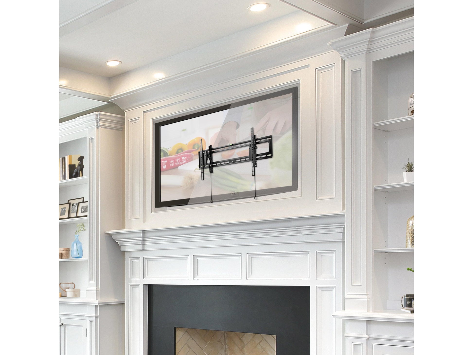 Tilting TV wall mount supporting 43" to 90" TVs, black metal frame with adjustable tilt mechanism, mounted on a beige living room wall, minimalist design with sleek, sturdy construction.