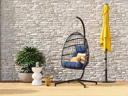 Blue hanging egg chair with cushioned seat, woven rattan design, and sturdy metal stand, perfect for patio relaxation.
