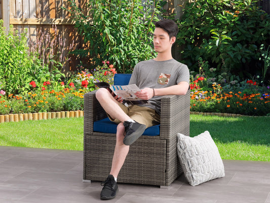 Wicker armchair with natural brown rattan weave, featuring a high back and curved armrests, paired with white cushions for outdoor patio use.