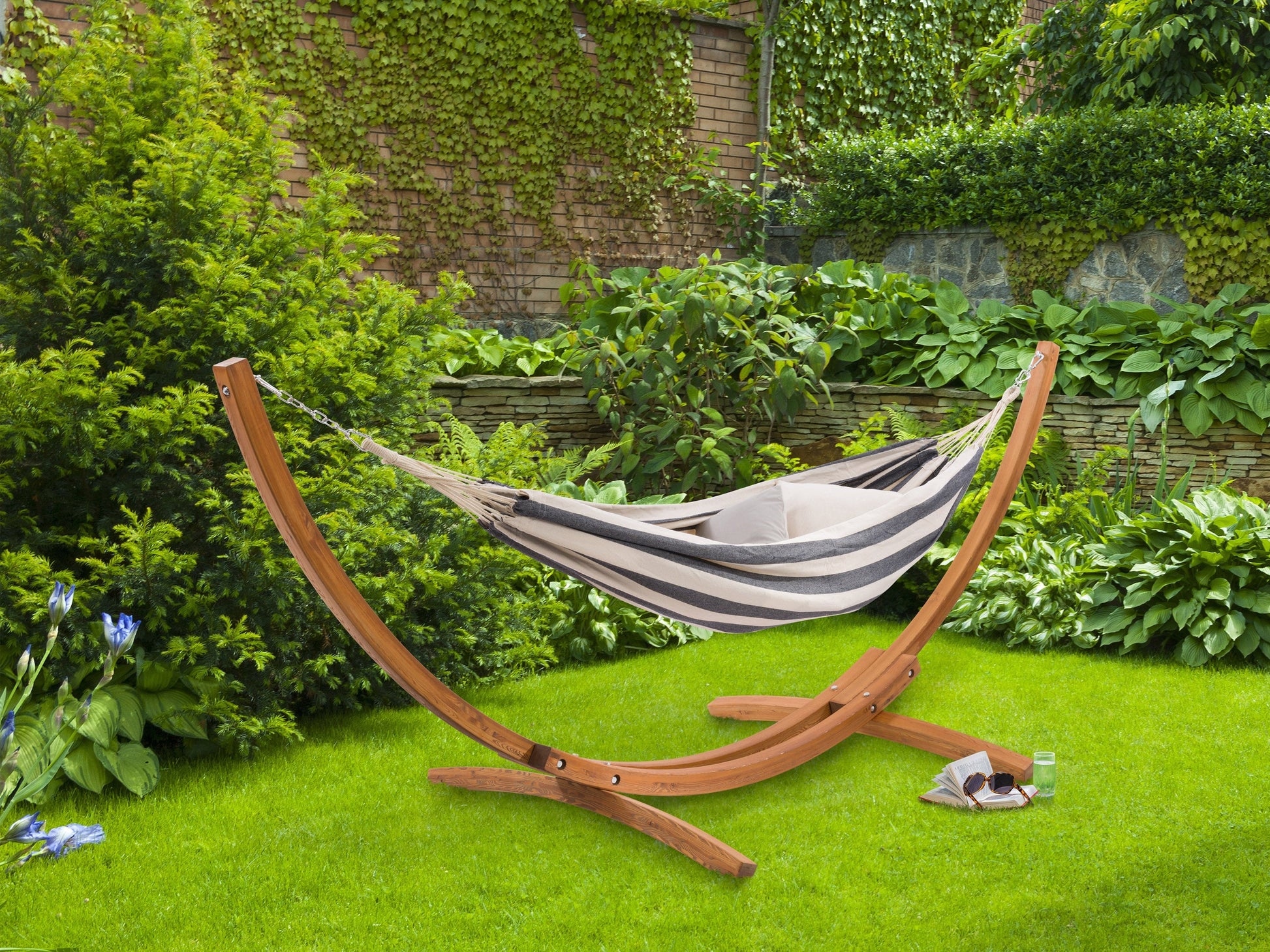 Navy blue and white striped patio hammock with wooden stand, featuring durable cotton fabric and sturdy, weather-resistant wood frame, perfect for outdoor relaxation and garden lounging.