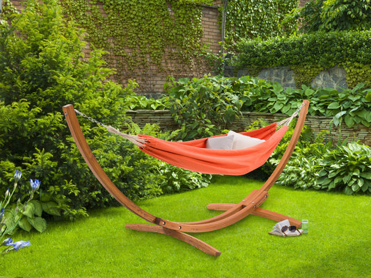 Orange patio hammock with sturdy wooden stand, featuring a woven fabric texture and curved wood frame, perfect for outdoor relaxation.