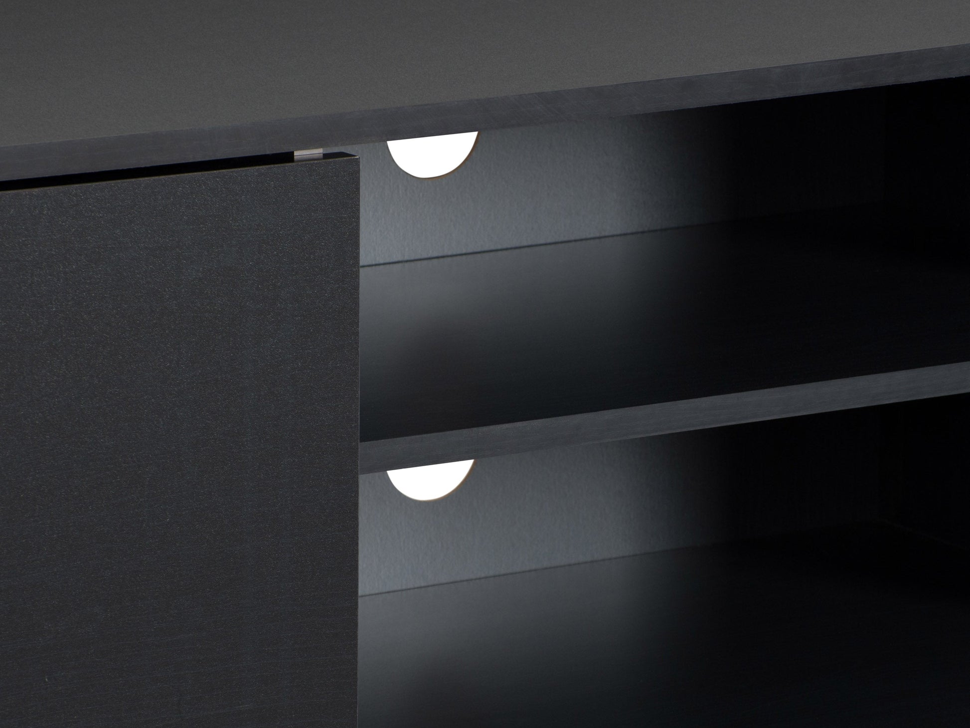 Modern black TV stand for TVs up to 85 inches, featuring sleek lines, minimalist design, and ample storage with open shelves and cabinets. Made of durable materials with a smooth finish.