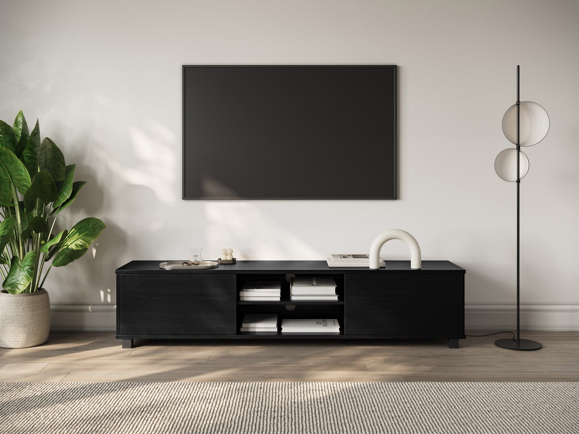 Modern black TV stand for TVs up to 85 inches, featuring sleek lines, minimalist design, and ample storage with open shelves and cabinets. Made of durable materials with a smooth finish.