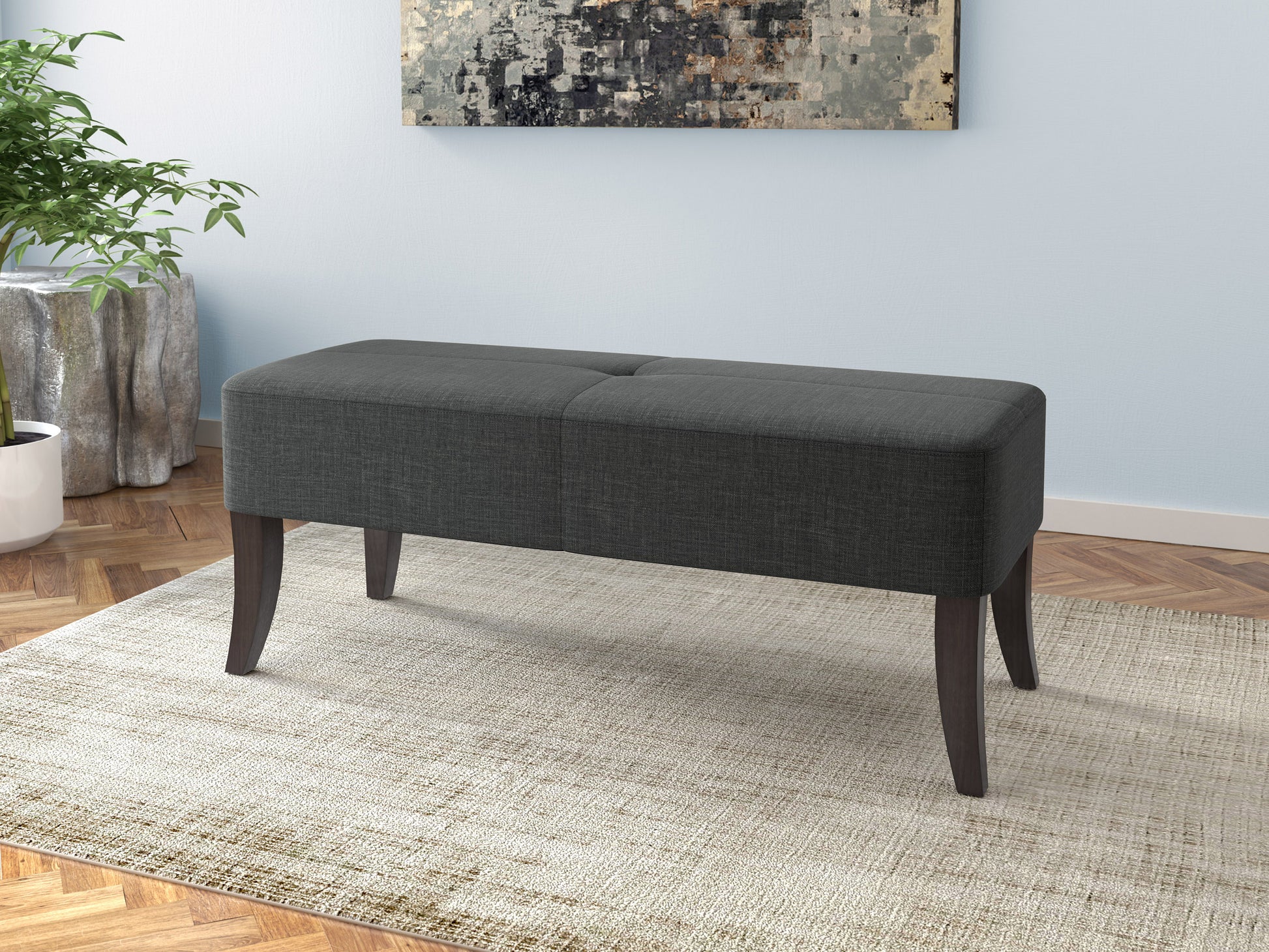 Gray upholstered bench with tufted seat, wooden legs, and brass nailhead trim. Perfect for entryways or bedrooms, blending modern and traditional styles.