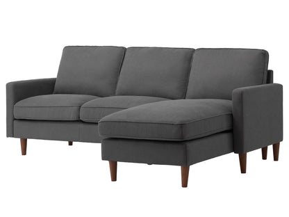 Reversible sectional sofa in light gray fabric with tufted cushions, chaise lounge, and wooden legs. Ideal for modern living rooms, offering comfort and flexibility in seating arrangements.
