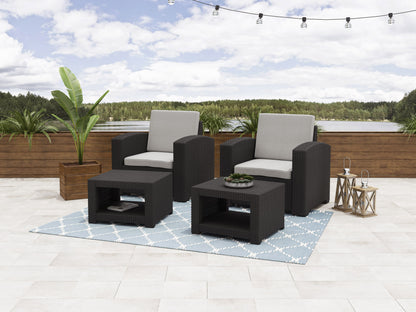 Outdoor patio conversation set with two gray cushioned chairs, matching ottomans, and a glass-top side table, featuring a sleek black metal frame and woven rattan accents, perfect for modern outdoor spaces.