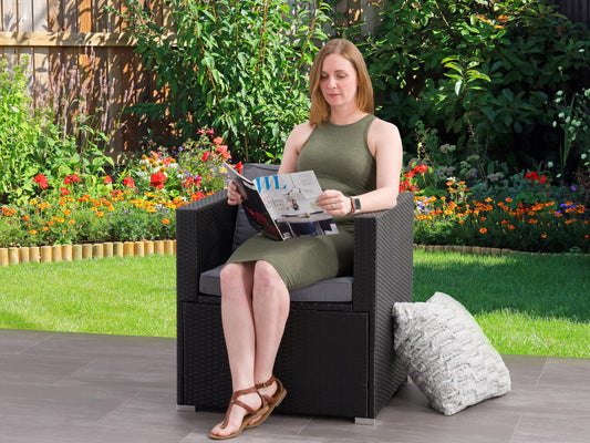 Natural wicker patio armchair with beige cushions, featuring a sturdy wooden frame and woven wicker texture. Ideal for outdoor relaxation in gardens or patios.