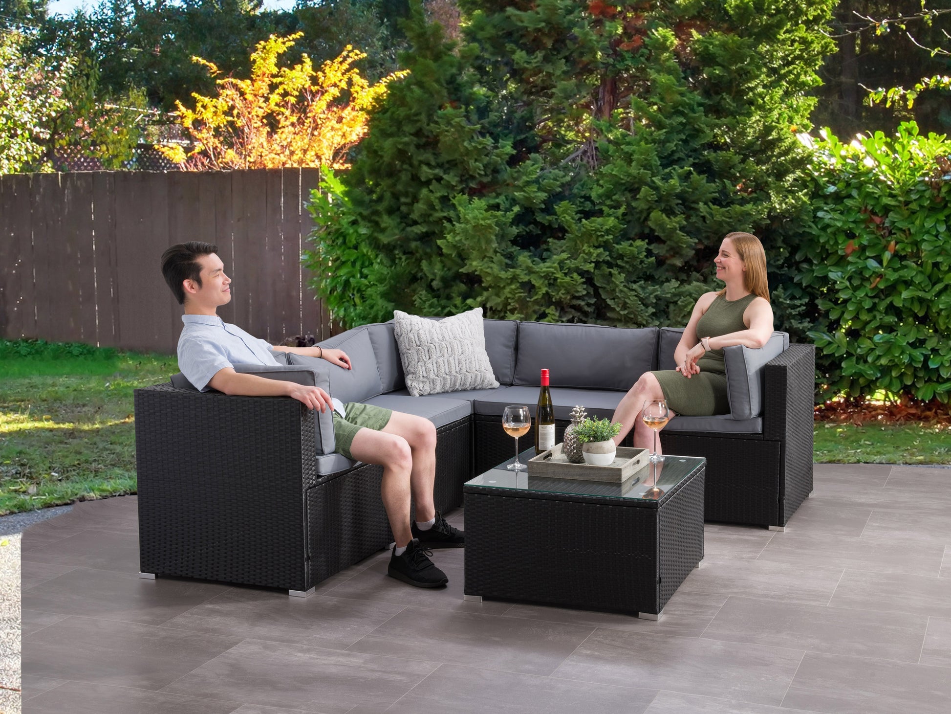 Outdoor patio sectional set, 6-piece, featuring gray cushions, brown wicker frame, includes corner and armless chairs, coffee table with glass top, perfect for garden or backyard lounging and entertaining.