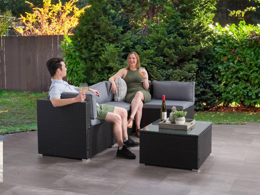 5-piece patio wicker sectional set with beige cushions, dark brown rattan frame, and glass-top coffee table on a wooden deck, featuring weather-resistant materials and modern outdoor design.